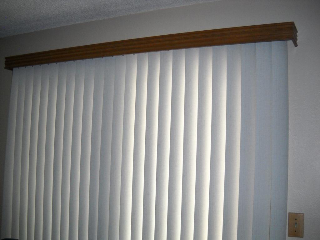 Decorative wood valance over vertical blinds from Budget Blinds in